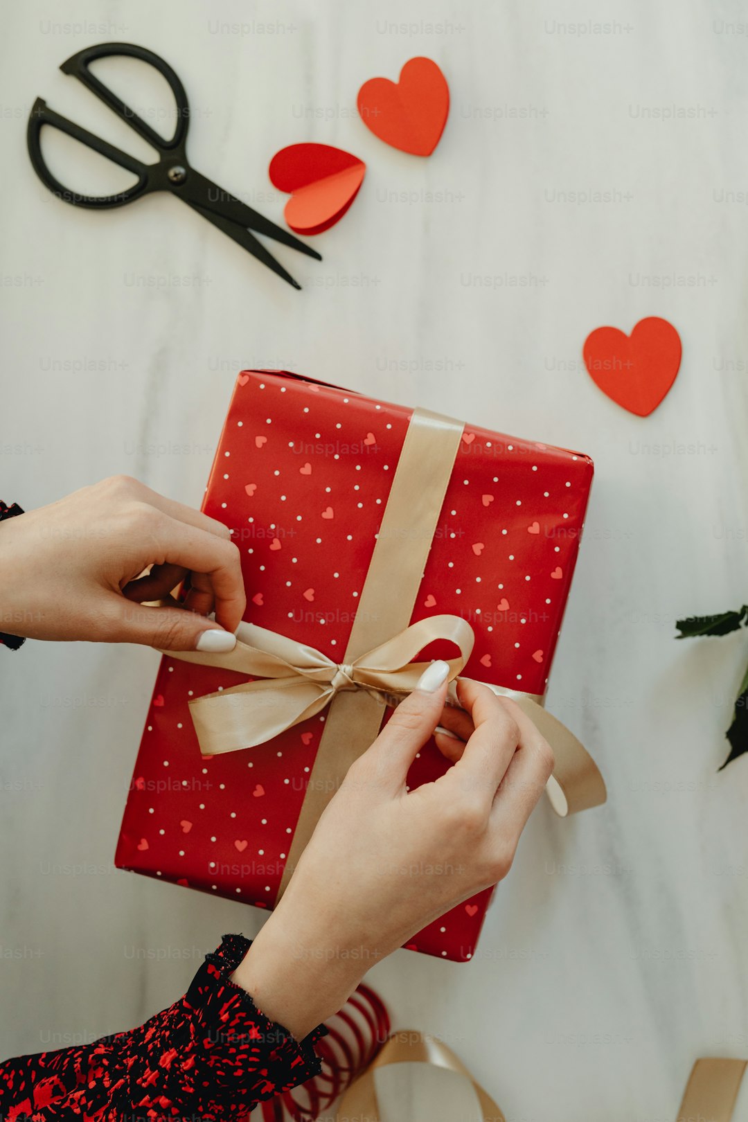 a woman is wrapping a gift with a ribbon