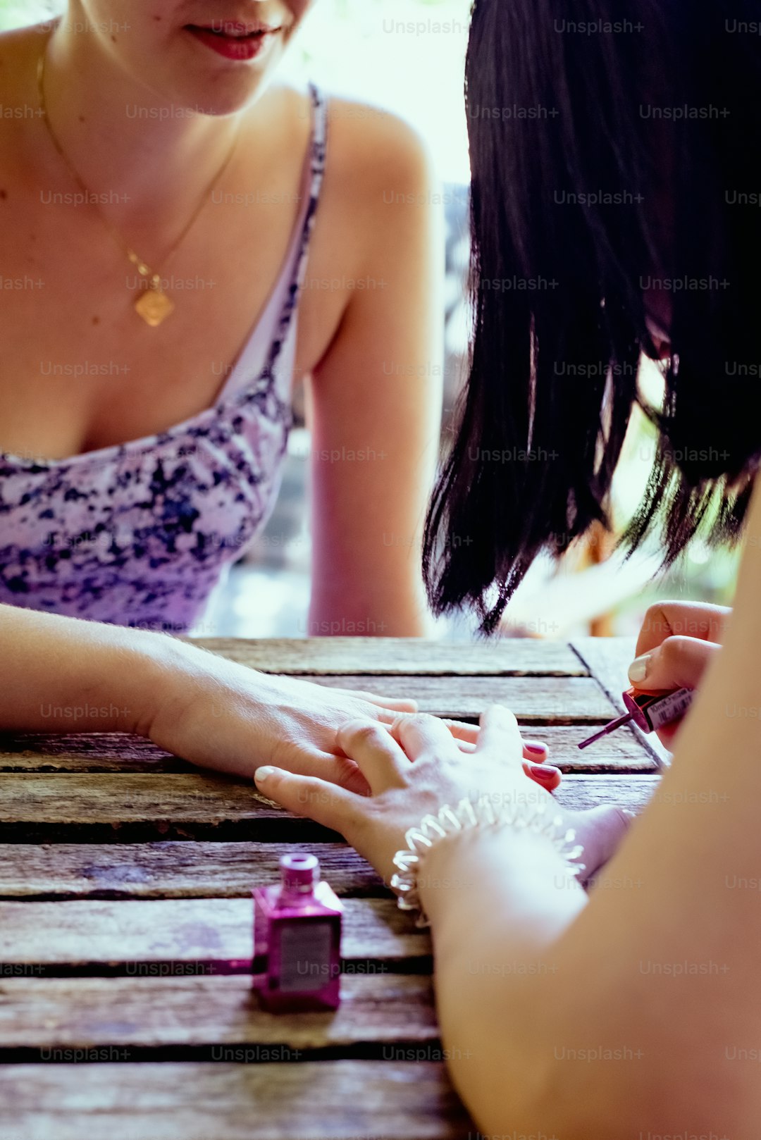 a woman sitting at a table with a bracelet on her hand