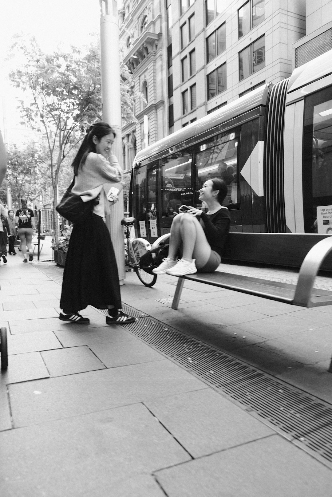 A woman sitting on a bench next to a train