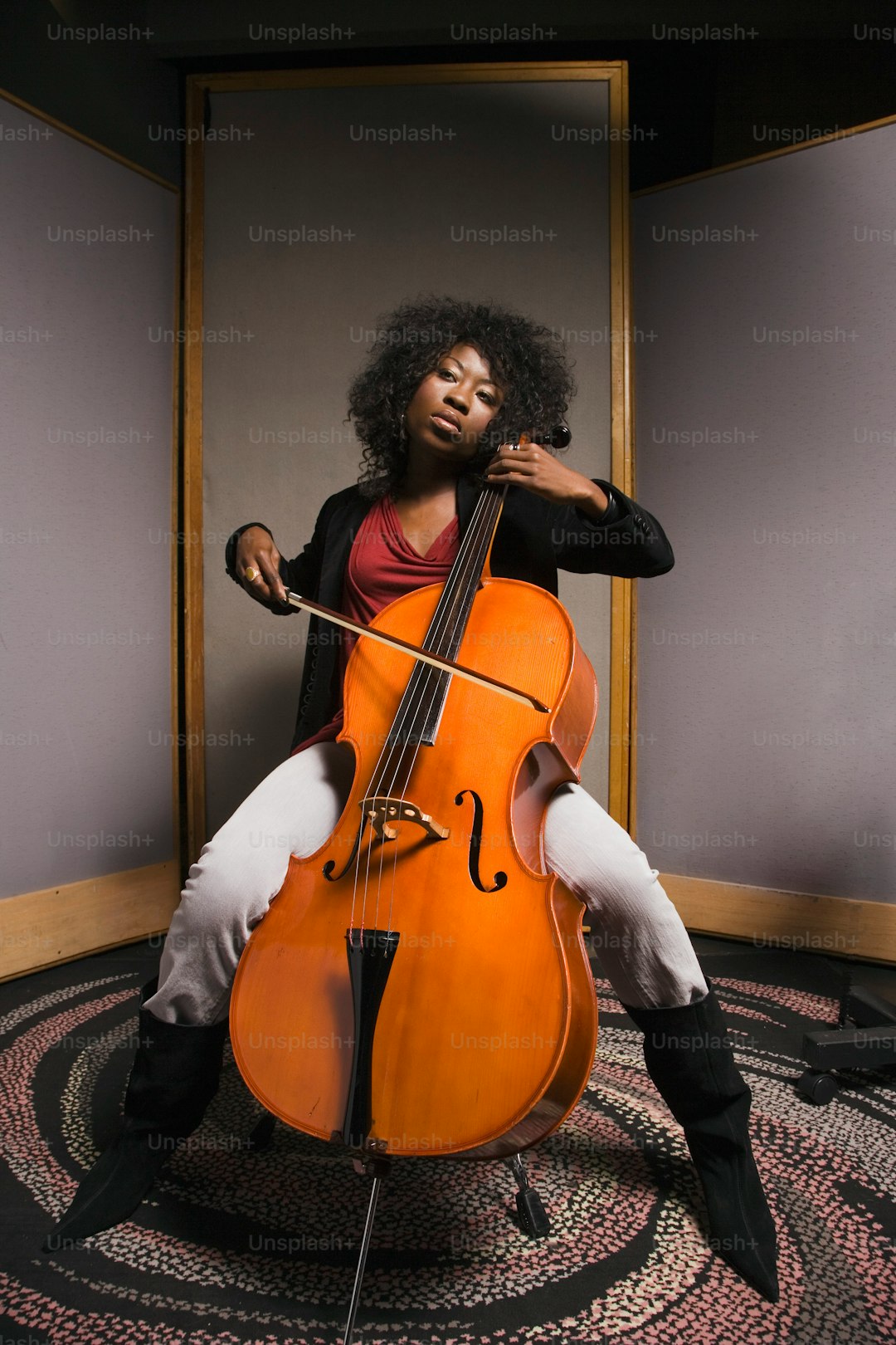 a woman sitting on a chair holding a cello