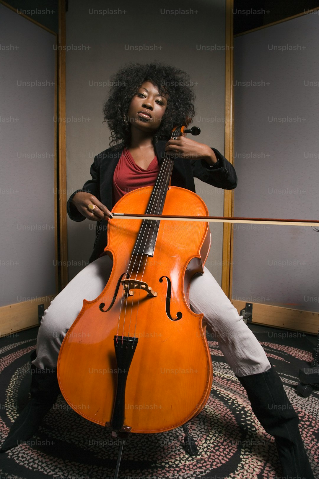 a woman sitting on a chair holding a cello