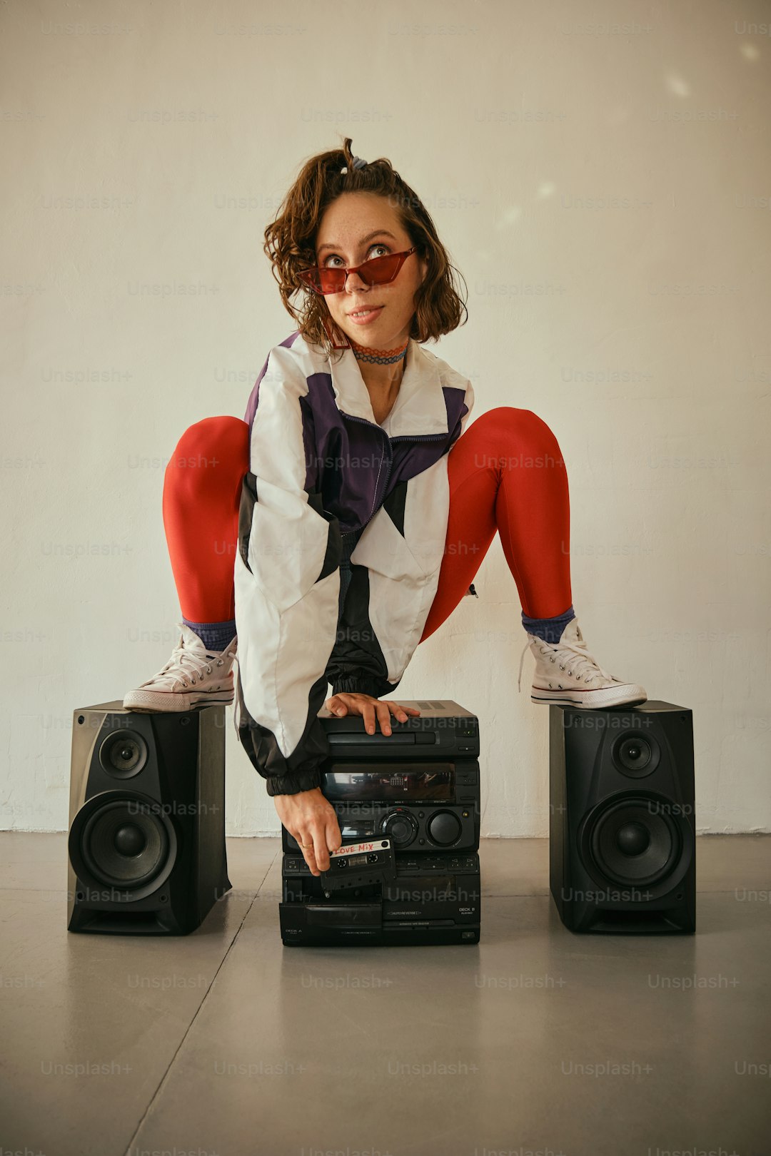 A woman sitting on top of two speakers