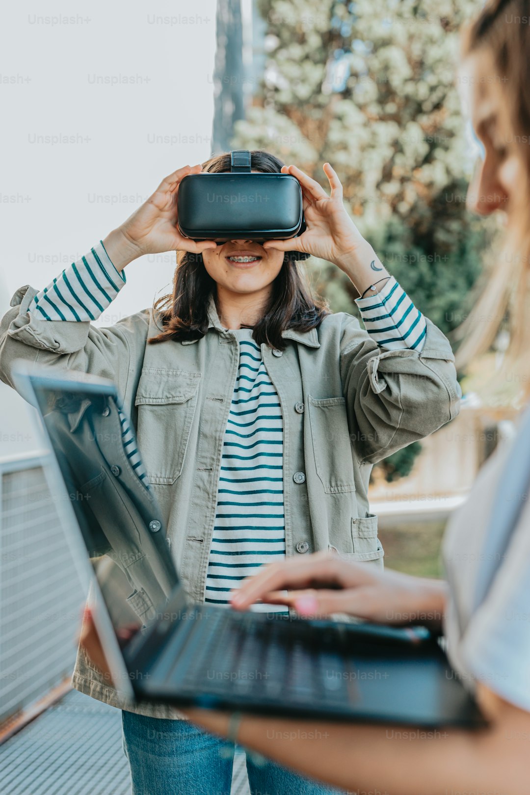 a woman using a laptop while wearing a virtual headset