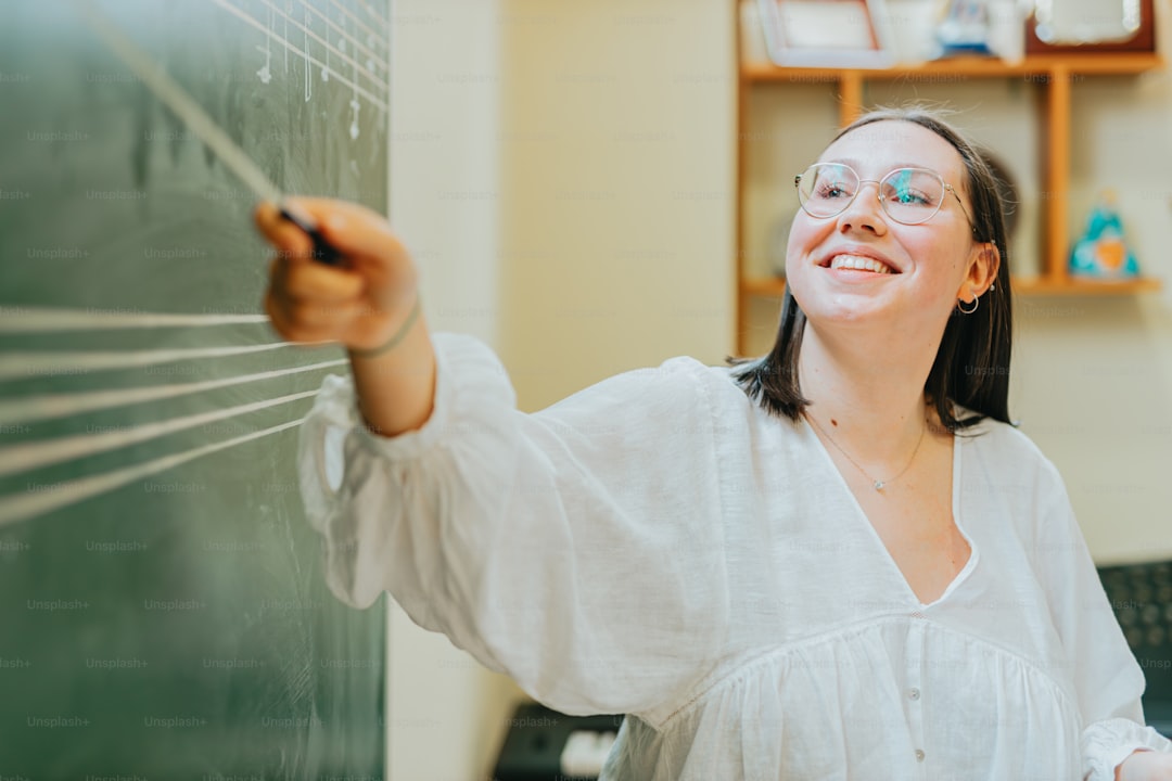 a woman writing on a blackboard in a classroom