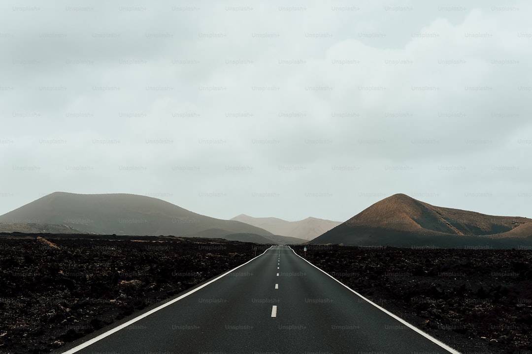 an empty road with mountains in the background