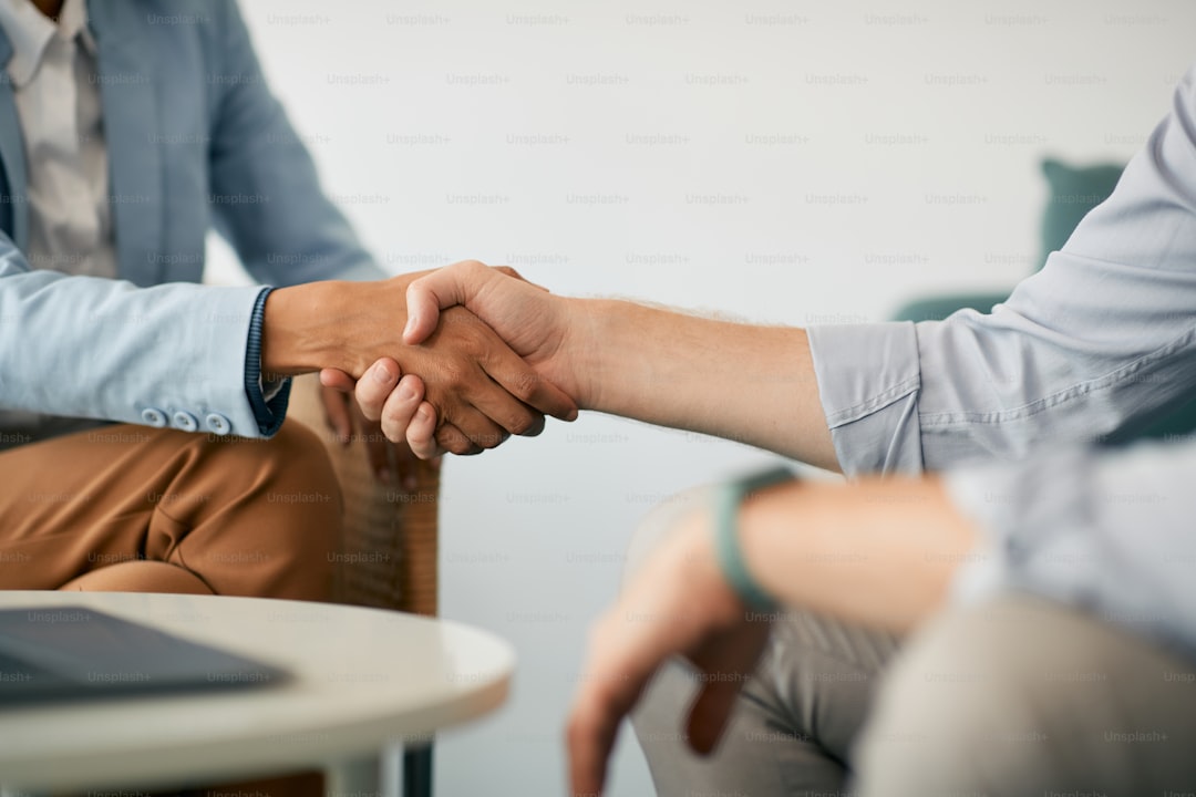 Close-up of coworkers shaking hands during business meeting in the office.