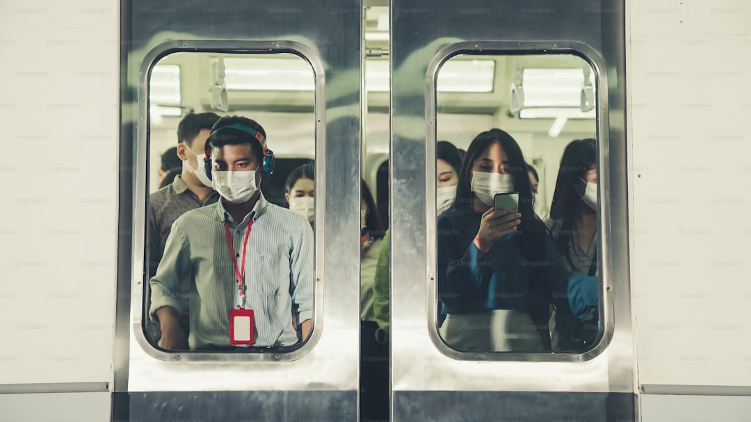 Crowd of people wearing face mask on a crowded public subway train travel . Coronavirus disease or COVID 19 pandemic outbreak and urban lifestyle problem in rush hour concept .