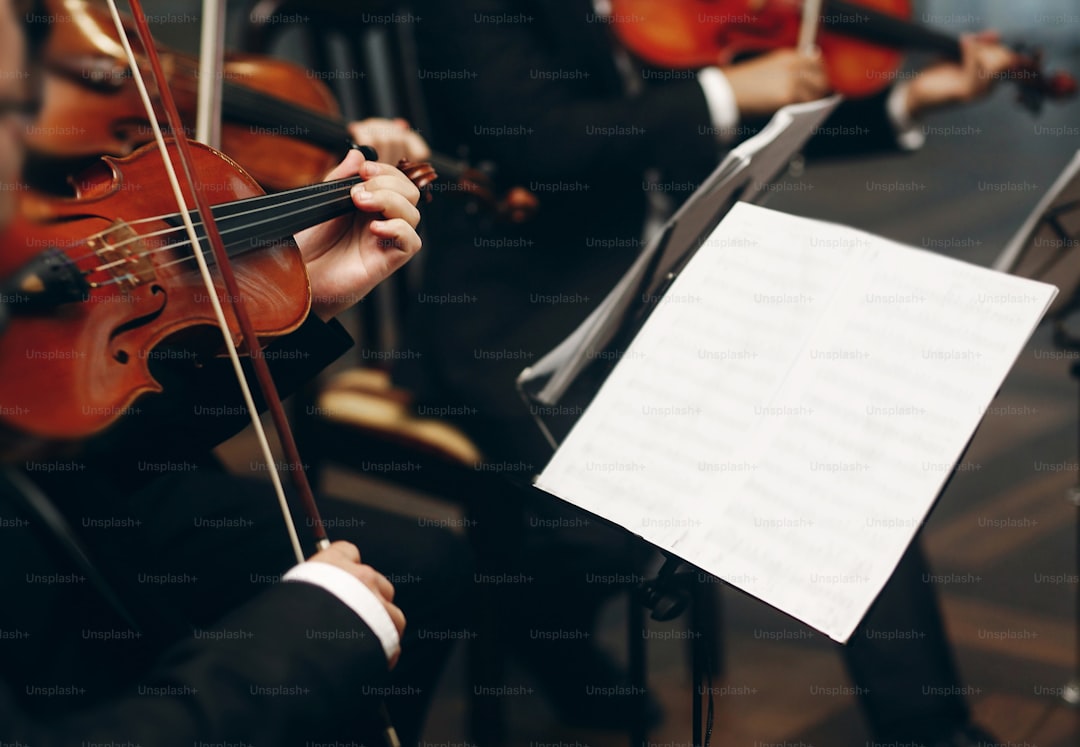 Elegant string quartet performing at wedding reception in restaurant, handsome man in suits playing violin and cello at theatre play orchestra close-up, music concept