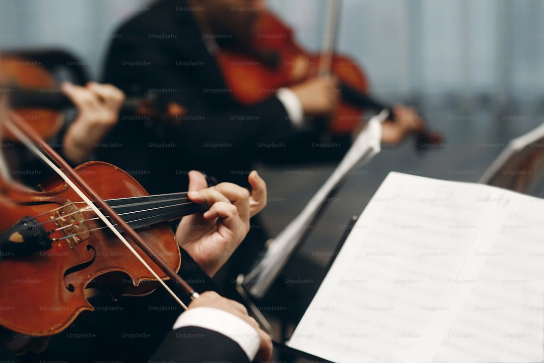 Elegant string quartet performing at wedding reception in restaurant, handsome man in suits playing violin and cello at theatre play orchestra close-up, music concept