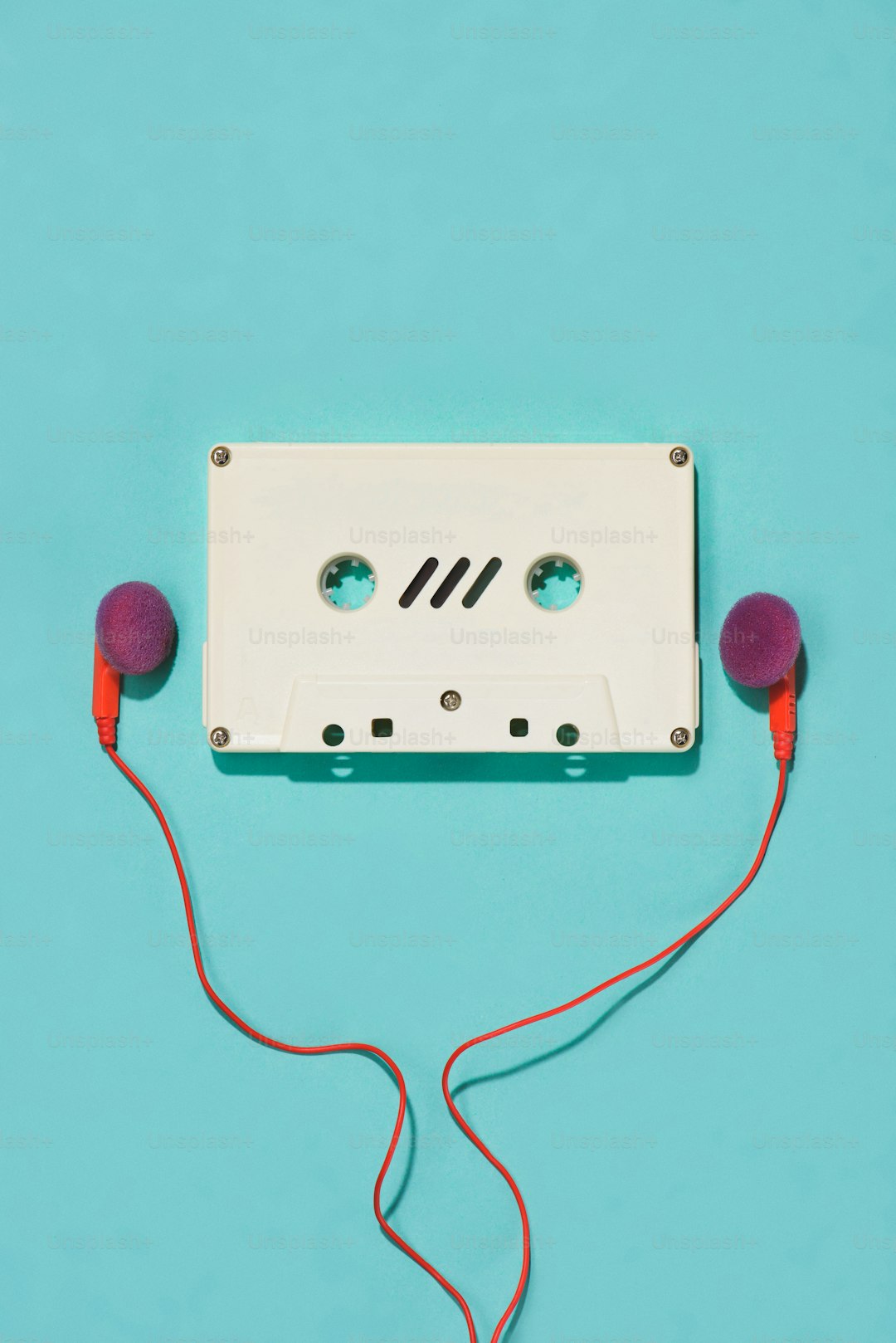 flat lay with white retro audio cassette and earphones isolated on blue