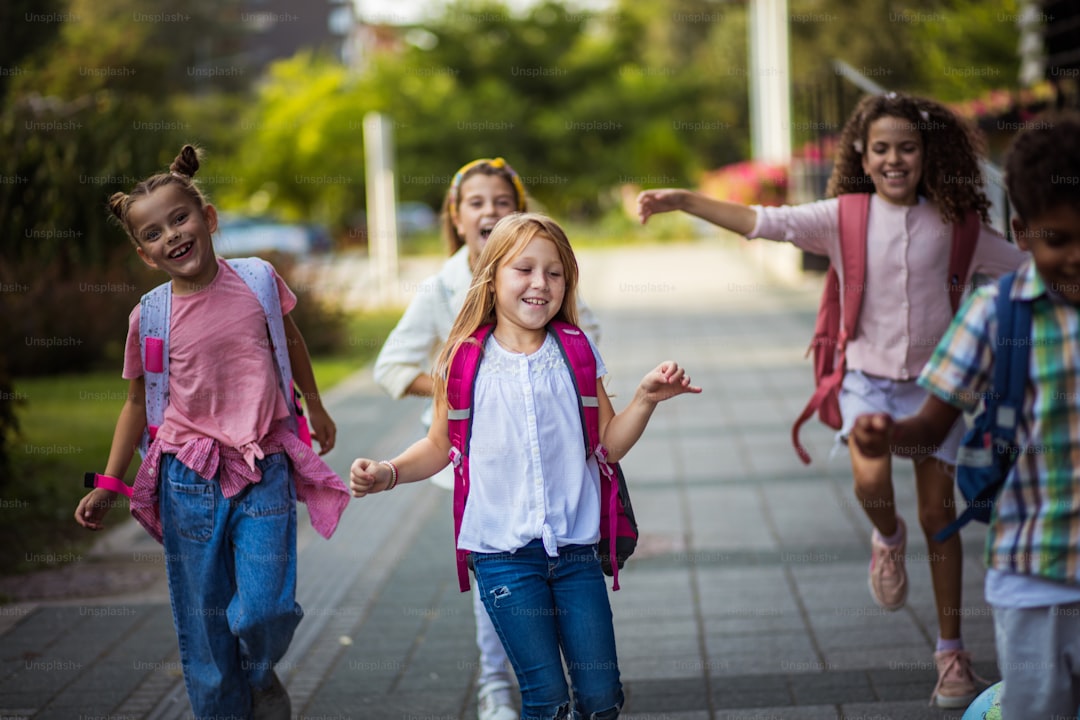 Group of elementary age schoolchildren outside. Kids having fun in school yard. Focus is on foreground.