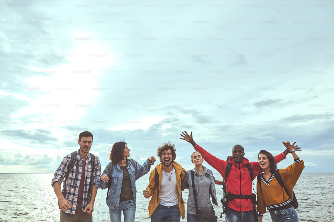 Having fun. Portrait of group of friends dedicating time to pleasure during their trip to the seashore