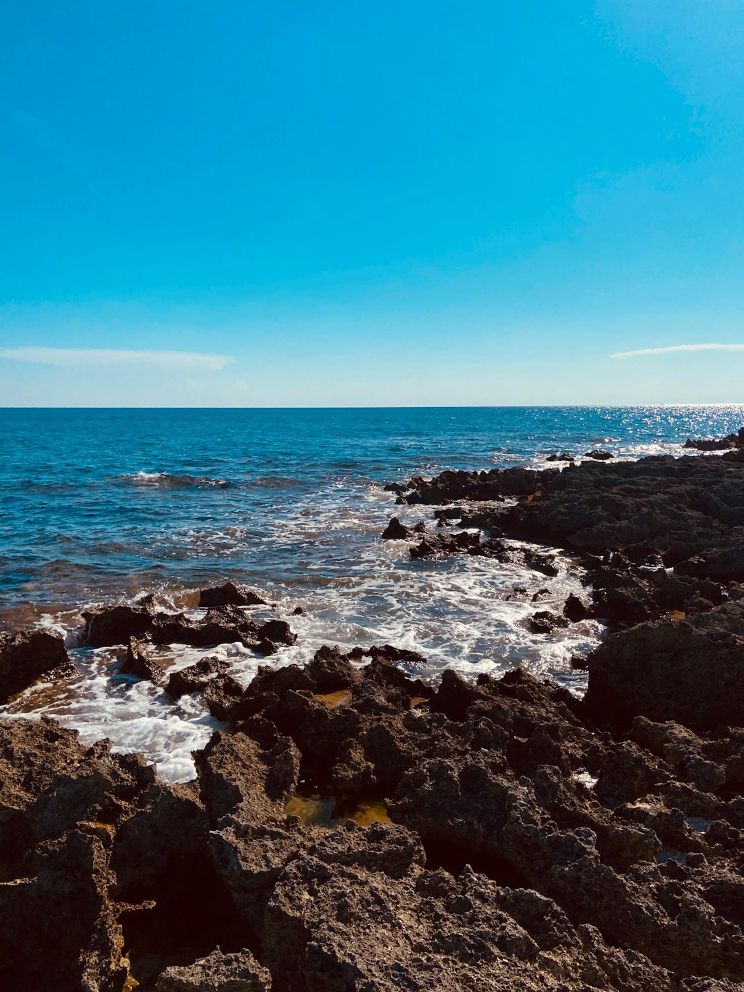 rocky shore under blue sky during daytime