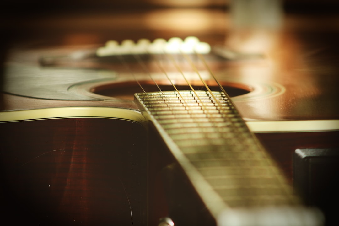 selective focus photography of wooden classical guitar