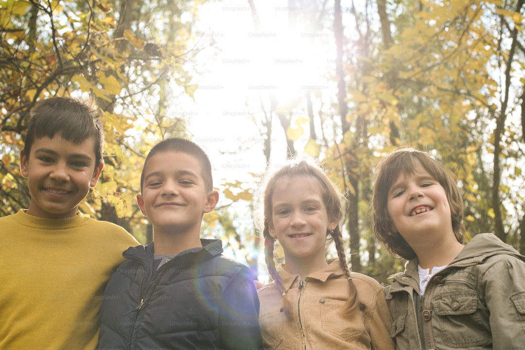 Small group of cheerful children looking at camera against sunset.