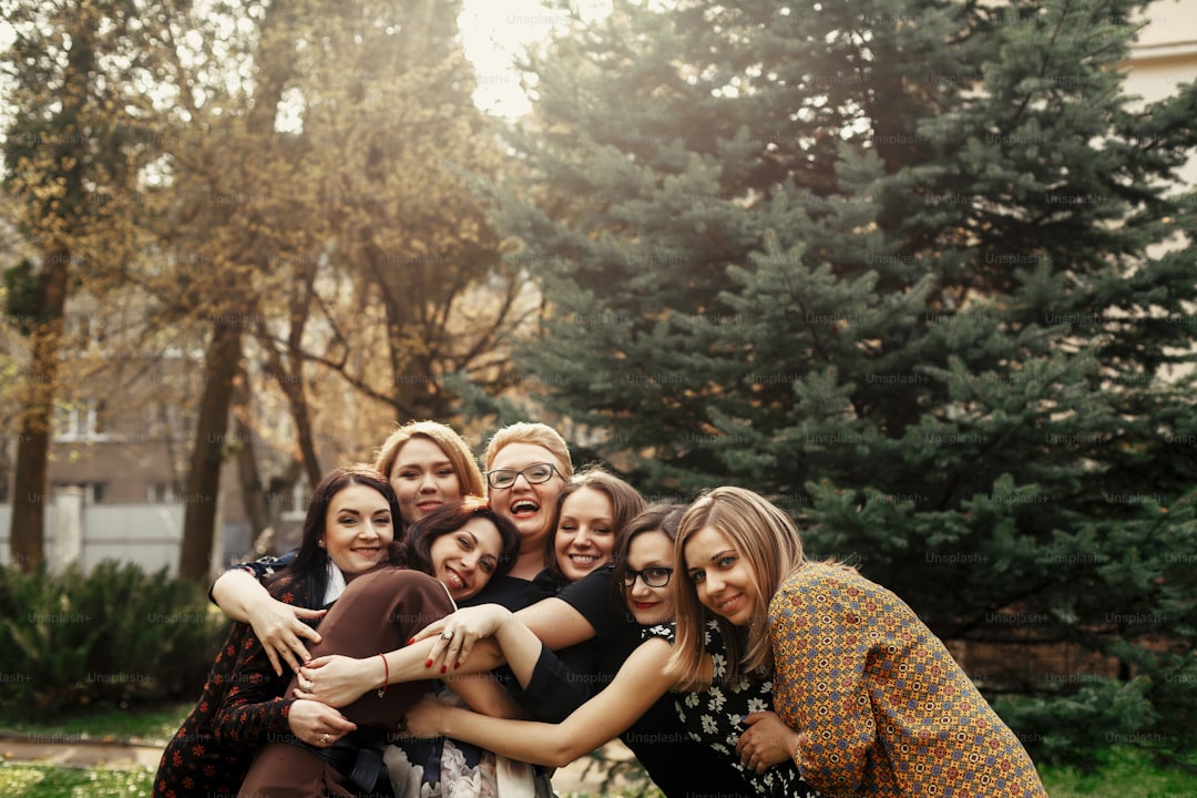 stylish elegant women having fun at celebration in sunny park, funny moment concept, gathering together