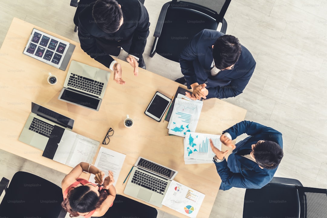 Successful business people celebrate together with joy at office table shot from top view . Young businessman and businesswoman workers express cheerful victory showing success by teamwork .