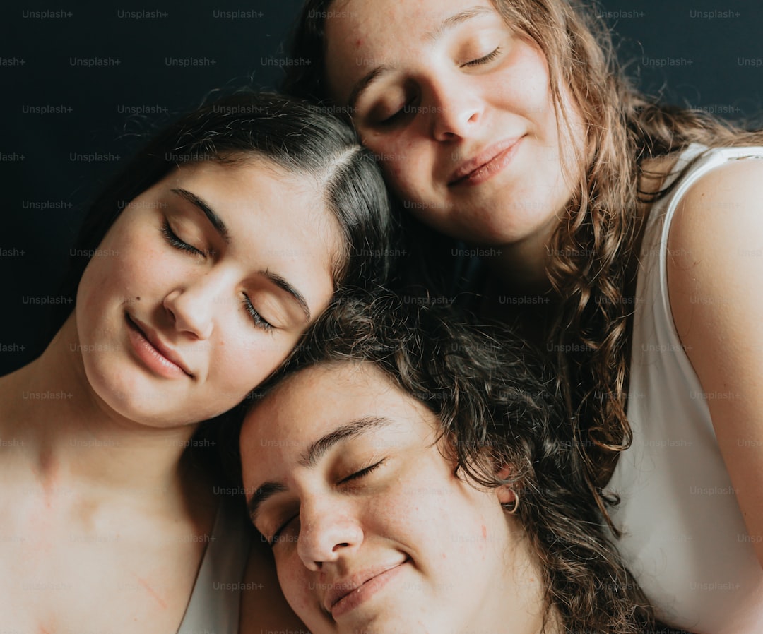 three women are looking at a cell phone