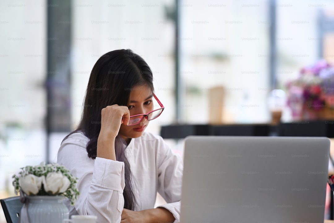 Tired businesswoman sitting in front of her laptop and feeling stress from work.