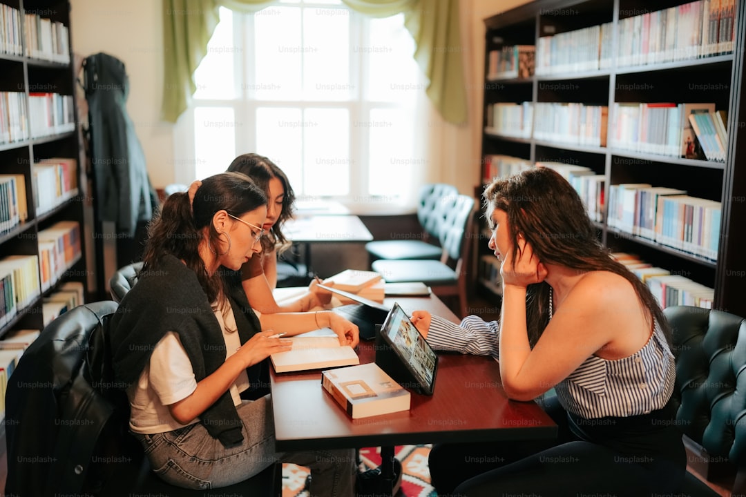 two women sitting at a table in a library