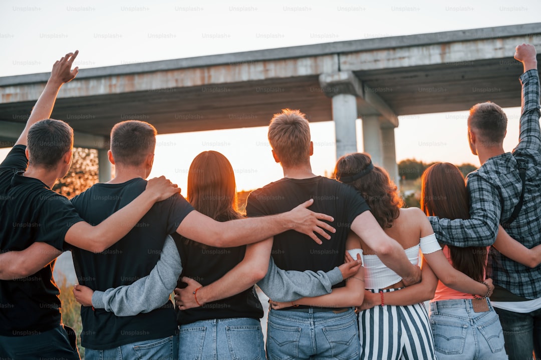 View from behind. Group of young cheerful friends having fun together. Party outdoors.