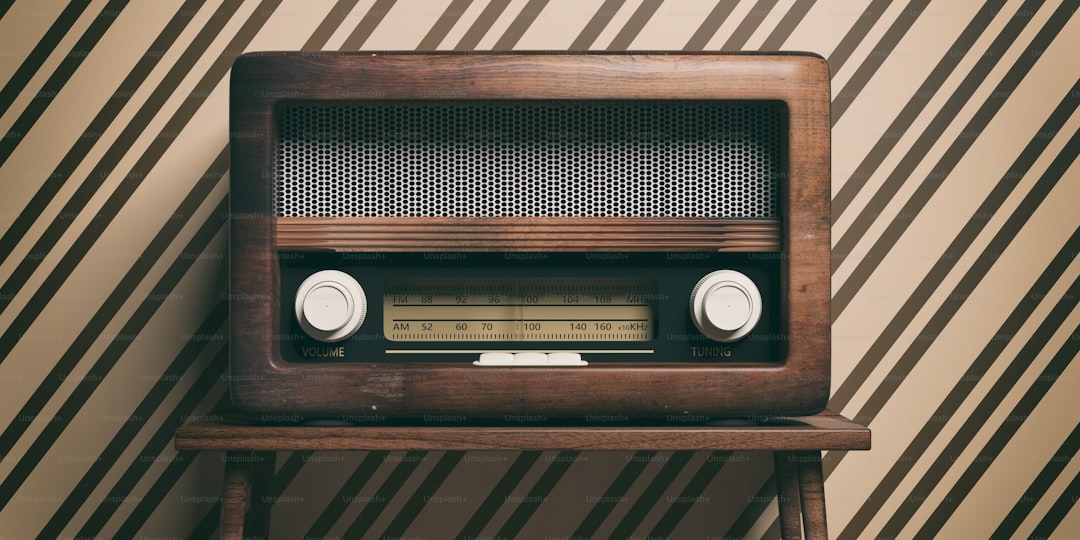 Vintage, retro radio. Radio old fashioned on wooden table, old fashioned wall background, 3d illustration