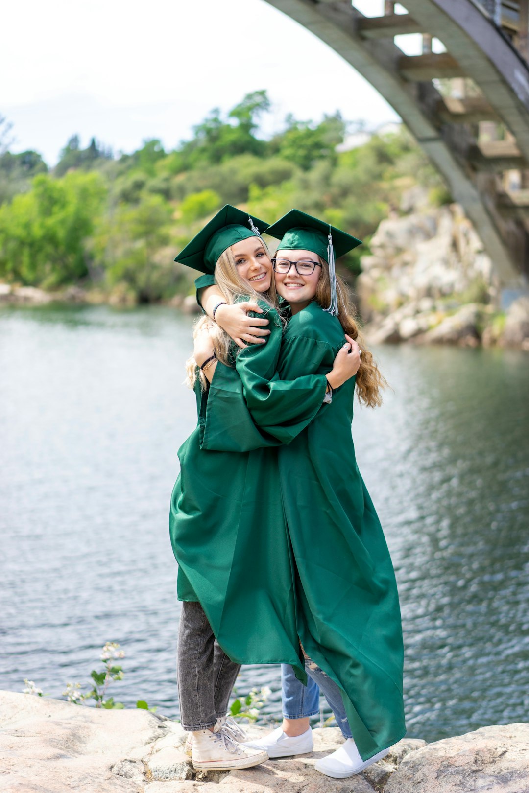 woman in green academic dress standing on gray concrete pavement during daytime