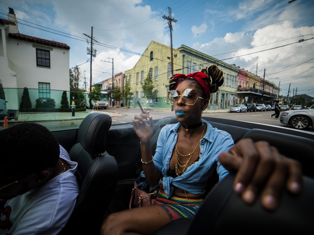 woman sitting on vehicle near concrete buildings