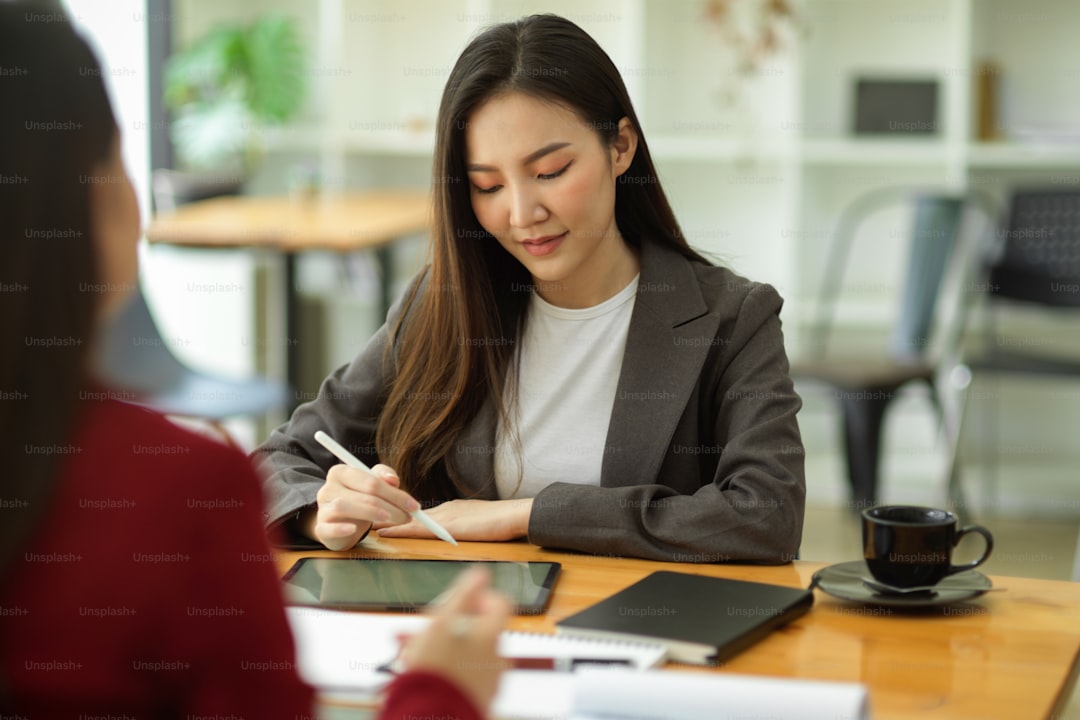 Young asian female startup learning business strategy from her mentor at co-working space.